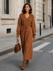Robe longue caramel col V — vue portée en marche sur un trottoir en ville