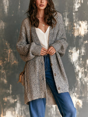 Cardigan gris ajouré col V — vue portée en pied, haut blanc et jean bleu, mains dans les poches latérales