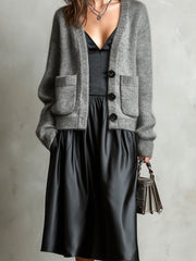 Ensemble robe noire cardigan gris — gros plan du haut du cardigan, du col en V et des boutons foncés