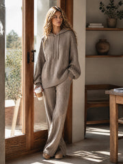 Ensemble maille capuche pantalon large — vue portée debout en intérieur près d'une fenêtre et d'une bibliothèque