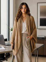 Cardigan camel asymétrique manches évasées — vue portée de face, dans un bureau, pantalon large clair