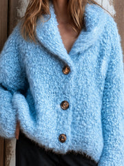Cardigan bleu à col châle — gros plan de la maille bouclée et d'un gros bouton marron