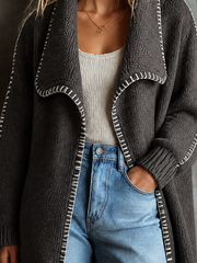 Cardigan gris foncé à surpiqûres contrastées.