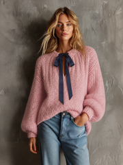 Pull rose poudré à nœud contrastant.
