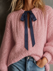 Pull rose poudré à nœud contrastant.
