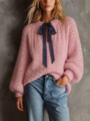 Pull rose poudré à nœud contrastant.