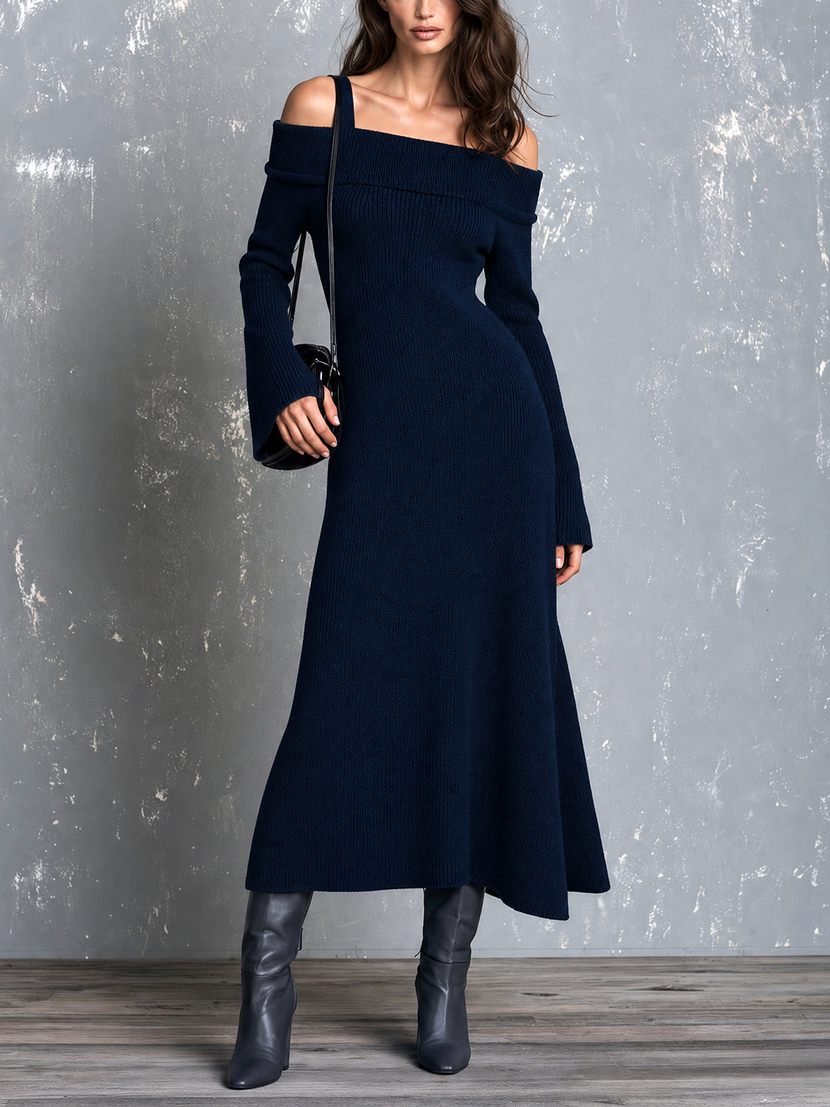 Robe maxi marine épaules dénudées — vue portée en pied, bottes noires pointues, devant un mur gris