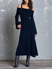 Robe maxi marine épaules dénudées — vue portée en pied, bottes noires pointues, devant un mur gris
