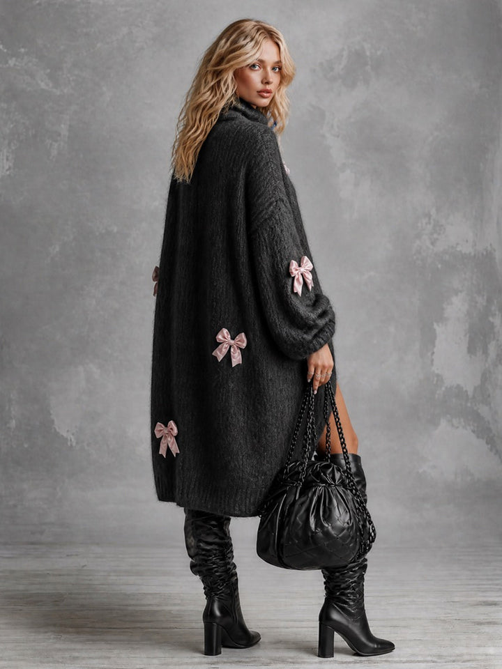Robe-pull noire à nœuds et ourlet asymétrique — détail du col. Soniel Paris.