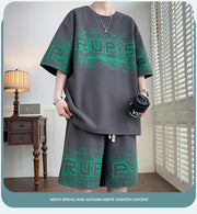T-shirt à motif lettre — gris foncé porté de face, gobelet en main