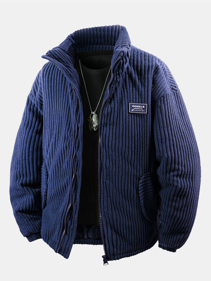 Veste côtelée bleue zippée vue de face, portée sur un haut noir avec collier