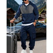 Ensemble sweat à capuche bleu marine — vue portée de face, valise à la main