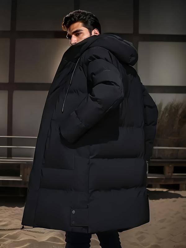 Manteau noir à capuche, porté de profil.