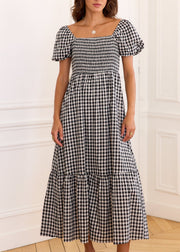 Robe vichy noir et blanc à encolure carrée, buste smocké et volant au bas de la jupe, vue de face.