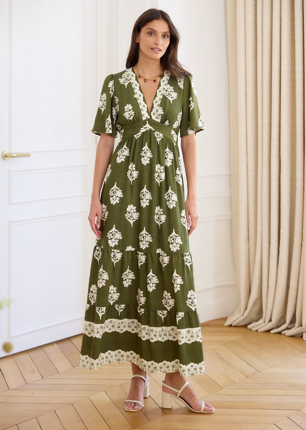 Robe longue kaki à motifs floraux écrus, manches courtes et décolleté en V, portée de face.