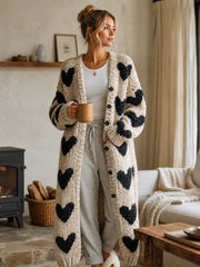 Gilet beige noir à cœurs — vue portée de face, près d'une cheminée