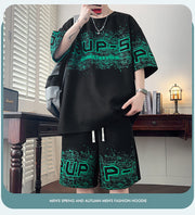 T-shirt à motif lettre — noir porté de face avec short assorti, imprimé vert