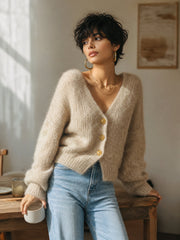 Gilet camel clair col V — vue portée assise sur un banc en bois, tasse à la main