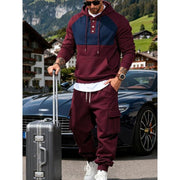 Ensemble sweat à capuche bordeaux — vue portée de face, valise à la main