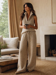 Ensemble maille camel pantalon large beige — vue portée dans un salon, verre à la main