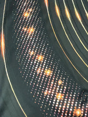 Polo demi-zip noir et or — gros plan du motif graphique à points lumineux