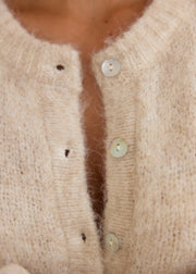 Gilet beige laine col rond — détail des boutons