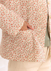 Veste blanche fleurie rose — gros plan du motif fleuri et de la poche