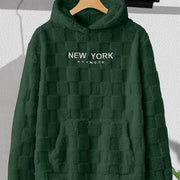 Sweat capuche damier vert foncé — pièce isolée sur cintre, face, inscription « NEW YORK »