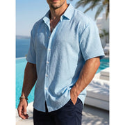Chemise d'été à manches courtes bleu clair — vue portée de profil, plan buste, devant une piscine