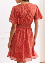 Robe courte rouge à petits motifs clairs, vue de dos avec taille smockée.