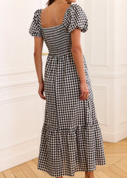 Robe vichy noir et blanc vue de dos de trois quarts, avec dos smocké et manches bouffantes.