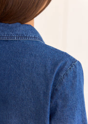 Détail du col au dos, des coutures et de la texture bleue de la robe Nesta en denim.
