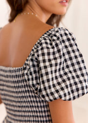 Détail de la manche bouffante et du dos smocké de la robe vichy noir et blanc.