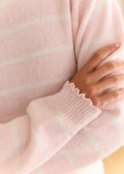 Pull rose rayé blanc — gros plan du poignet et de la maille