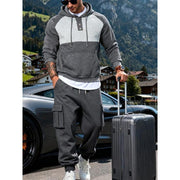 Ensemble sweat à capuche gris foncé — vue portée de face, debout près de la valise