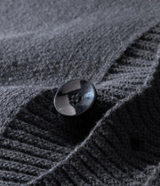 Détail du bouton à quatre trous et de la patte de boutonnage du cardigan gris anthracite.