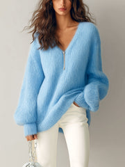 Gilet bleu zippé maille duveteuse — vue portée de face, main dans la poche d'un pantalon blanc