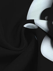 T-shirt noir à motif yeux — gros plan du tissu et du bord du motif