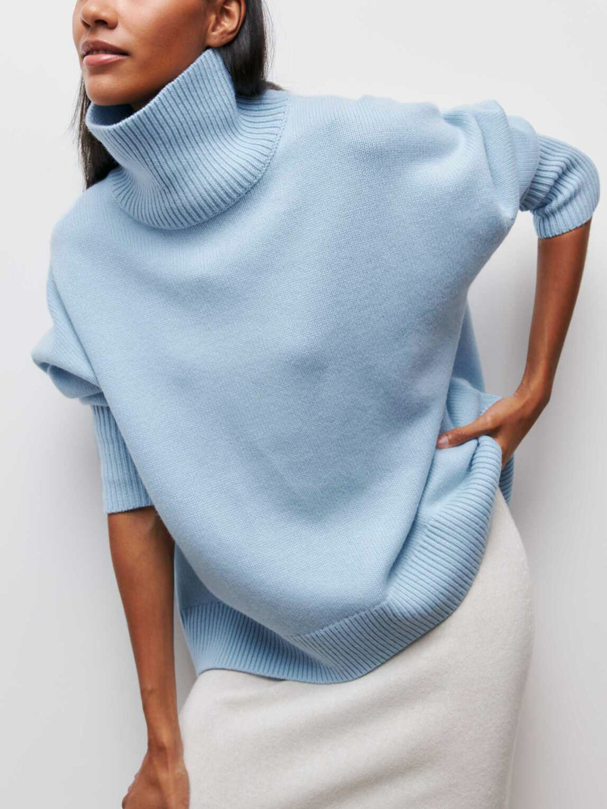 Pull oversize col roulé bleu ciel — vue portée de trois-quarts, regard de côté