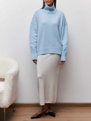 Pull oversize col roulé bleu ciel — vue portée en pied, jupe longue blanche et ballerines noires