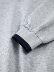 Sweat oversize finitions contrastées gris clair — gros plan sur le poignet côtelé bleu marine
