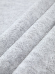 Pull asymétrique épaule dénudée gris clair — gros plan sur la maille chinée