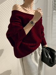 Pull asymétrique épaule dénudée bordeaux — vue portée de face, épaule dénudée, sac noir