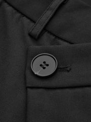 Pantalon ample à devant asymétrique noir, détail du bouton