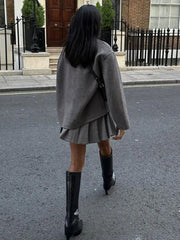 Veste oversize à boutons gris anthracite — vue portée de dos, en marche dans la rue