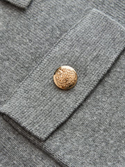 Ensemble jupe tricot boutons métal gris — gros plan sur un bouton métallique doré