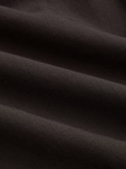 Pantalon jambe large ourlet irrégulier brun foncé, détail du tissu