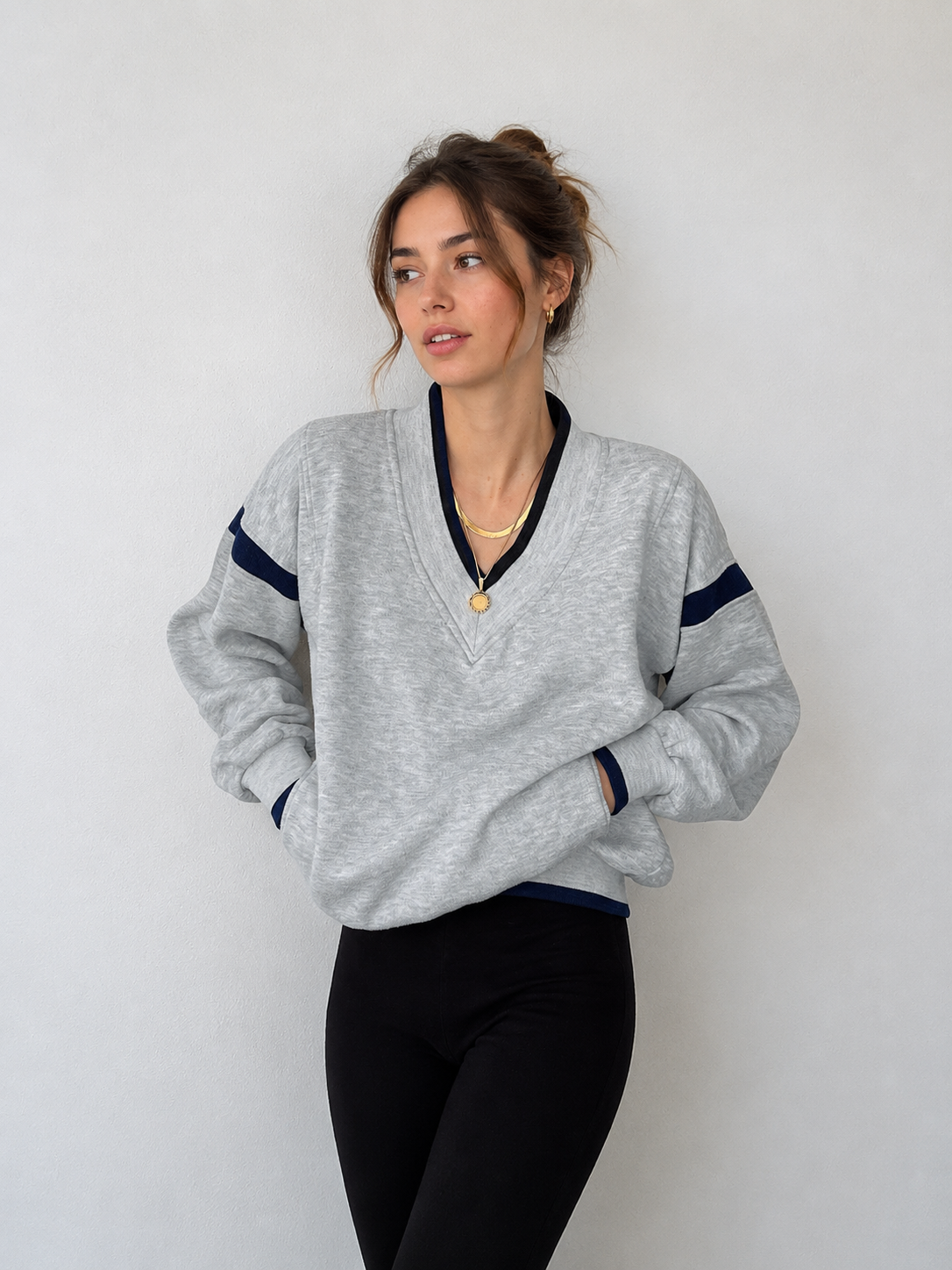 Sweat oversize finitions contrastées gris clair — vue portée de face, cadrée à la taille, col en V rayé bleu marine