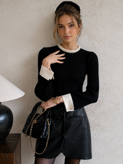 Pull bord contrasté perles noir — vue portée de face, sac noir à la main, détail des manches