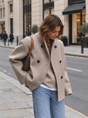 Veste oversize à boutons beige — vue portée de trois-quarts en extérieur, regard vers le bas